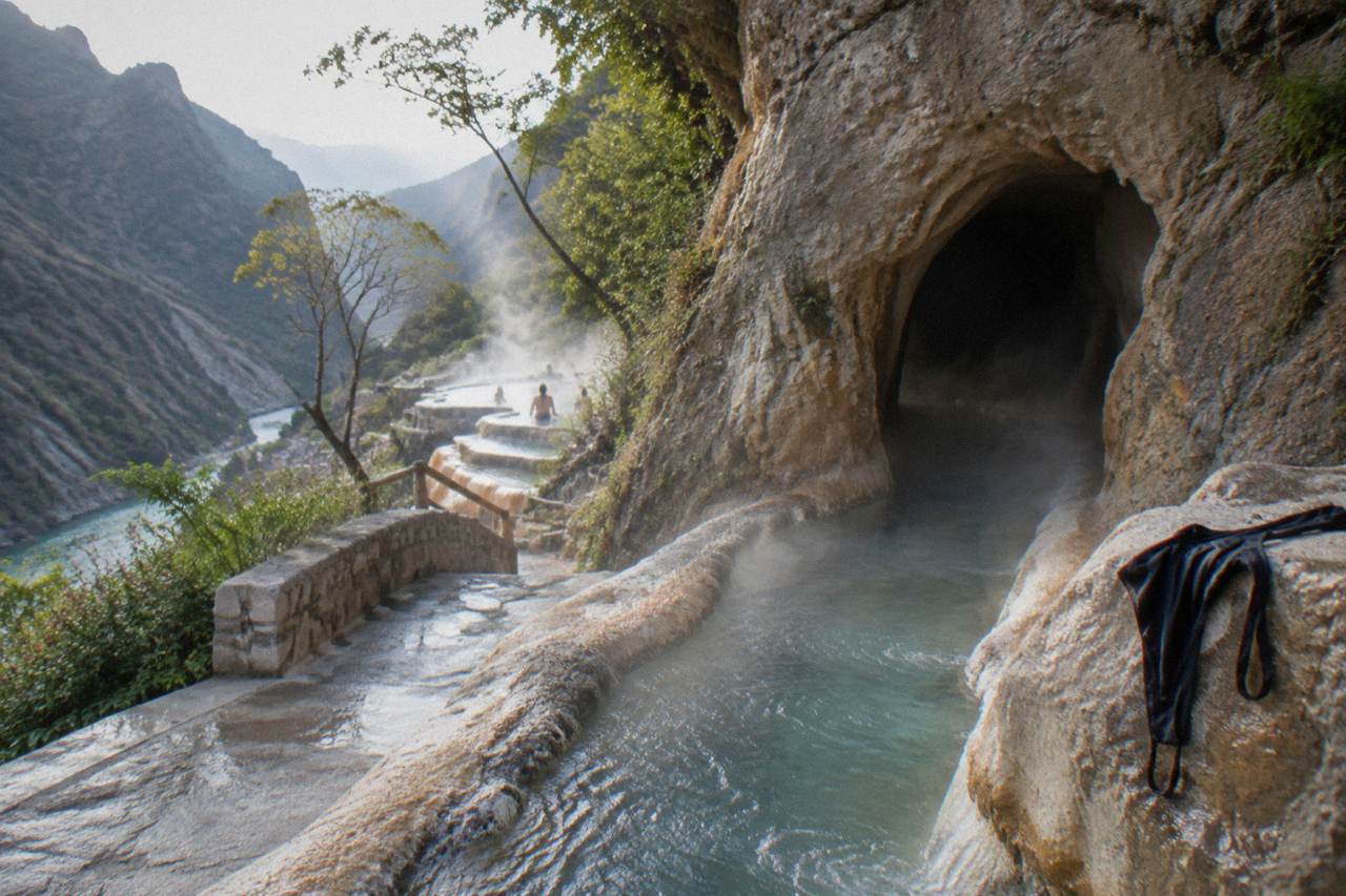 A thermal water channel flowing out of a rock tunnel toward an open canyon