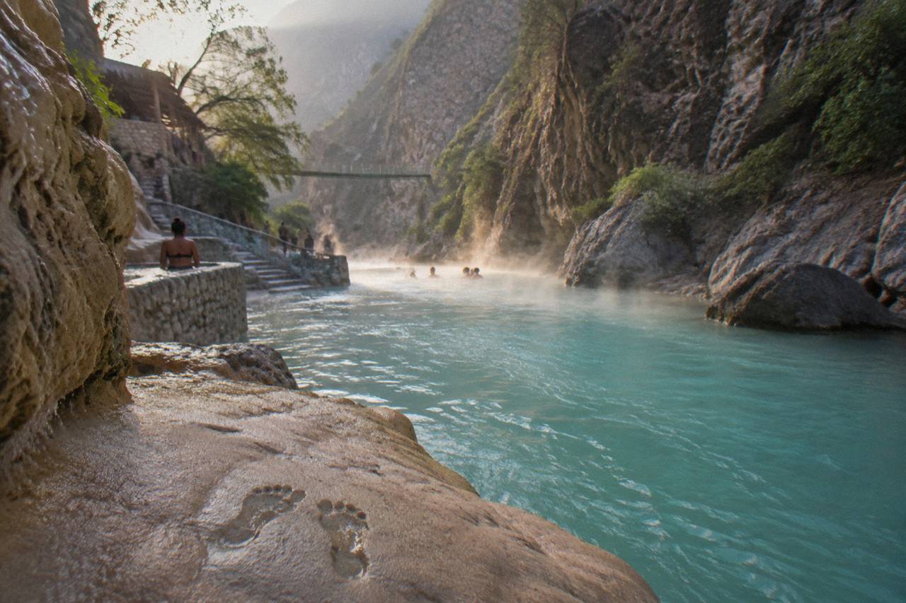 Warm thermal river flowing between steep canyon walls under morning light