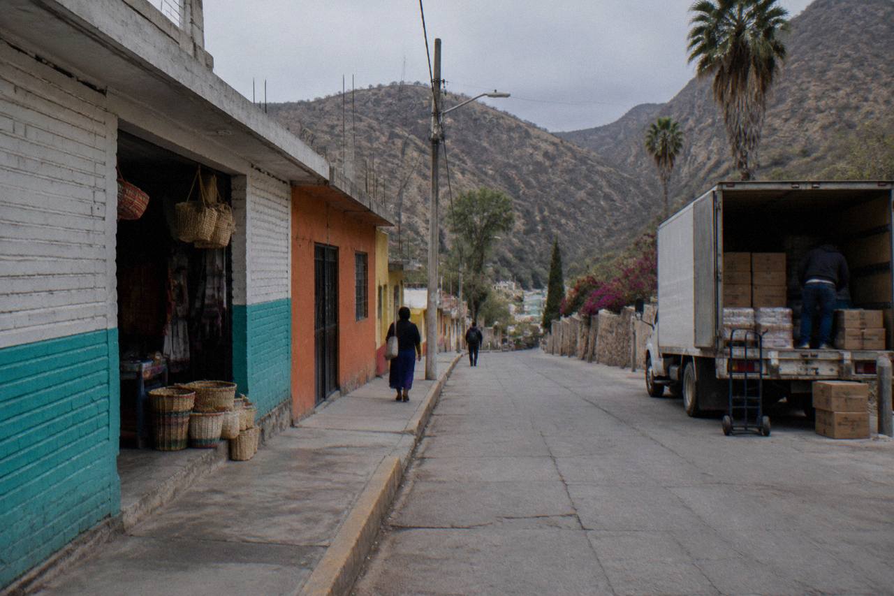 Small town street in the Mezquital Valley with hills rising behind low buildings