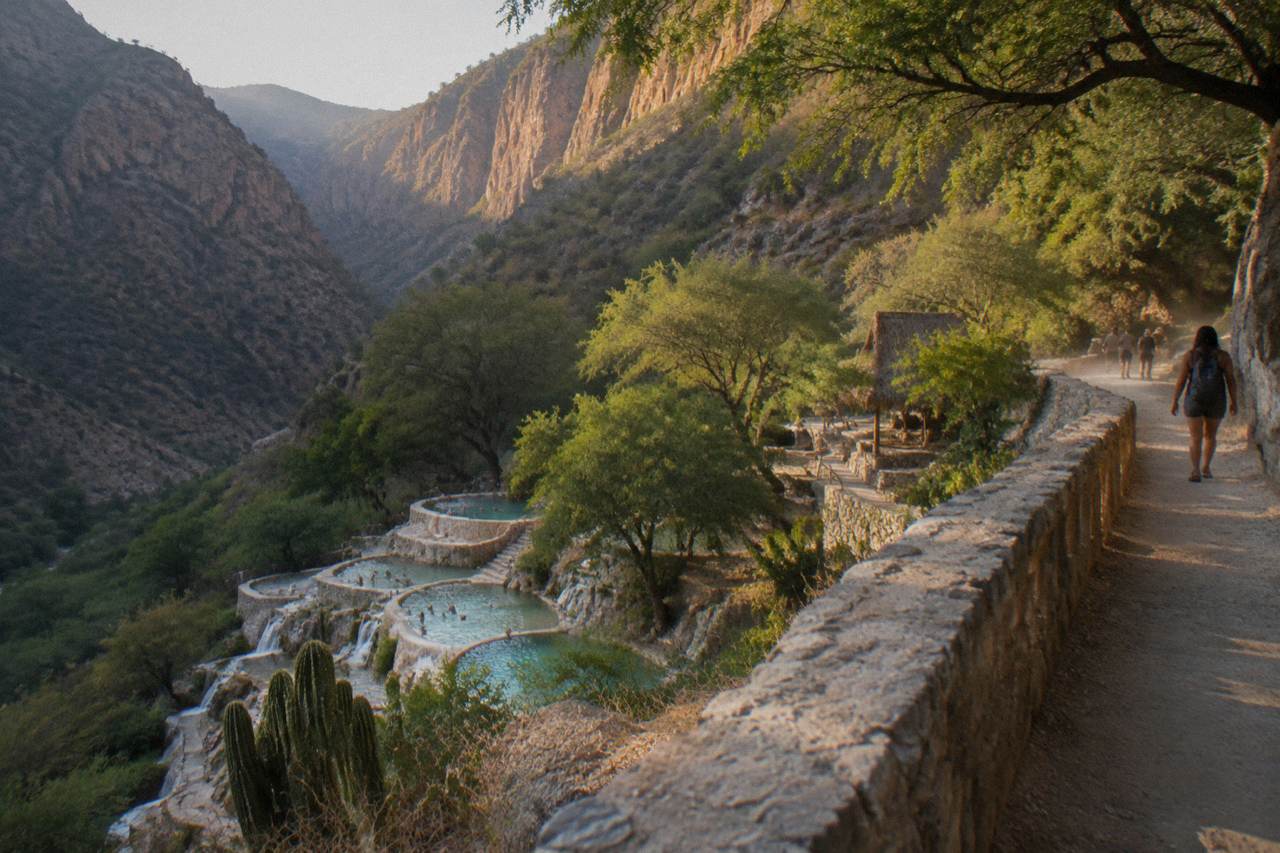 Canyon cliffs and green vegetation above the thermal pools at Grutas de Tolantongo in late afternoon light