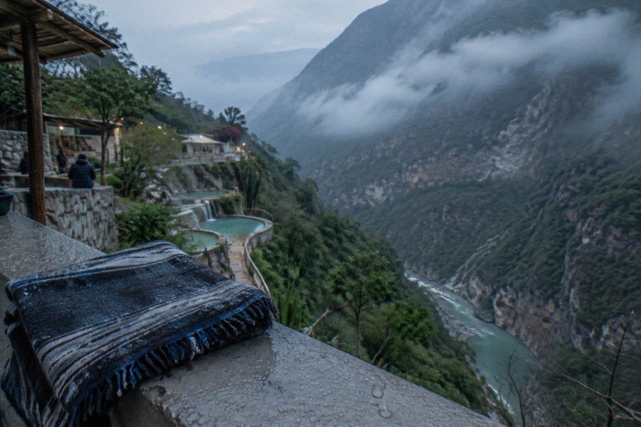 Clouds resting over a steep green canyon at dawn with a river far below