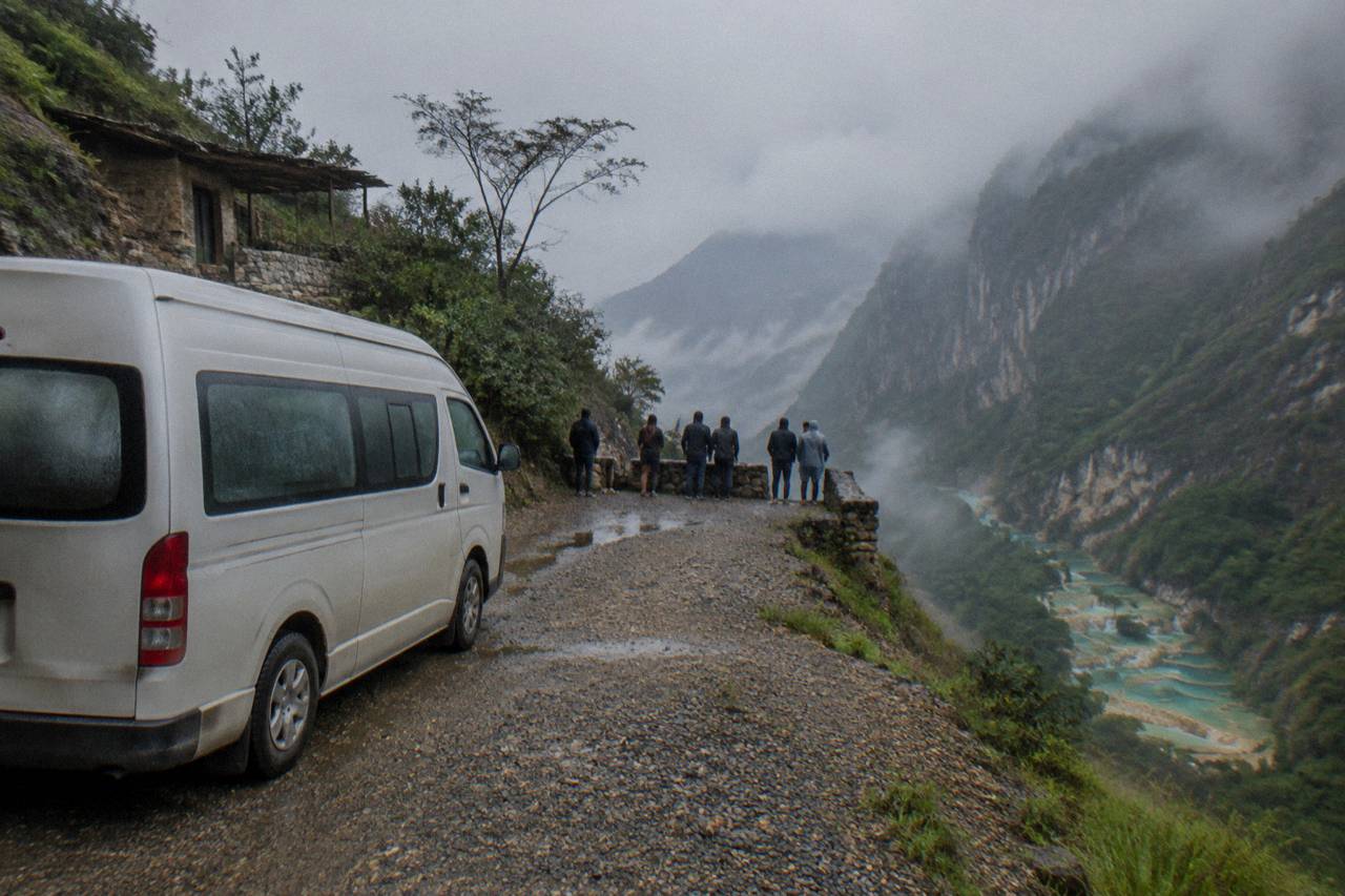 A tour van parked at a roadside viewpoint above a canyon