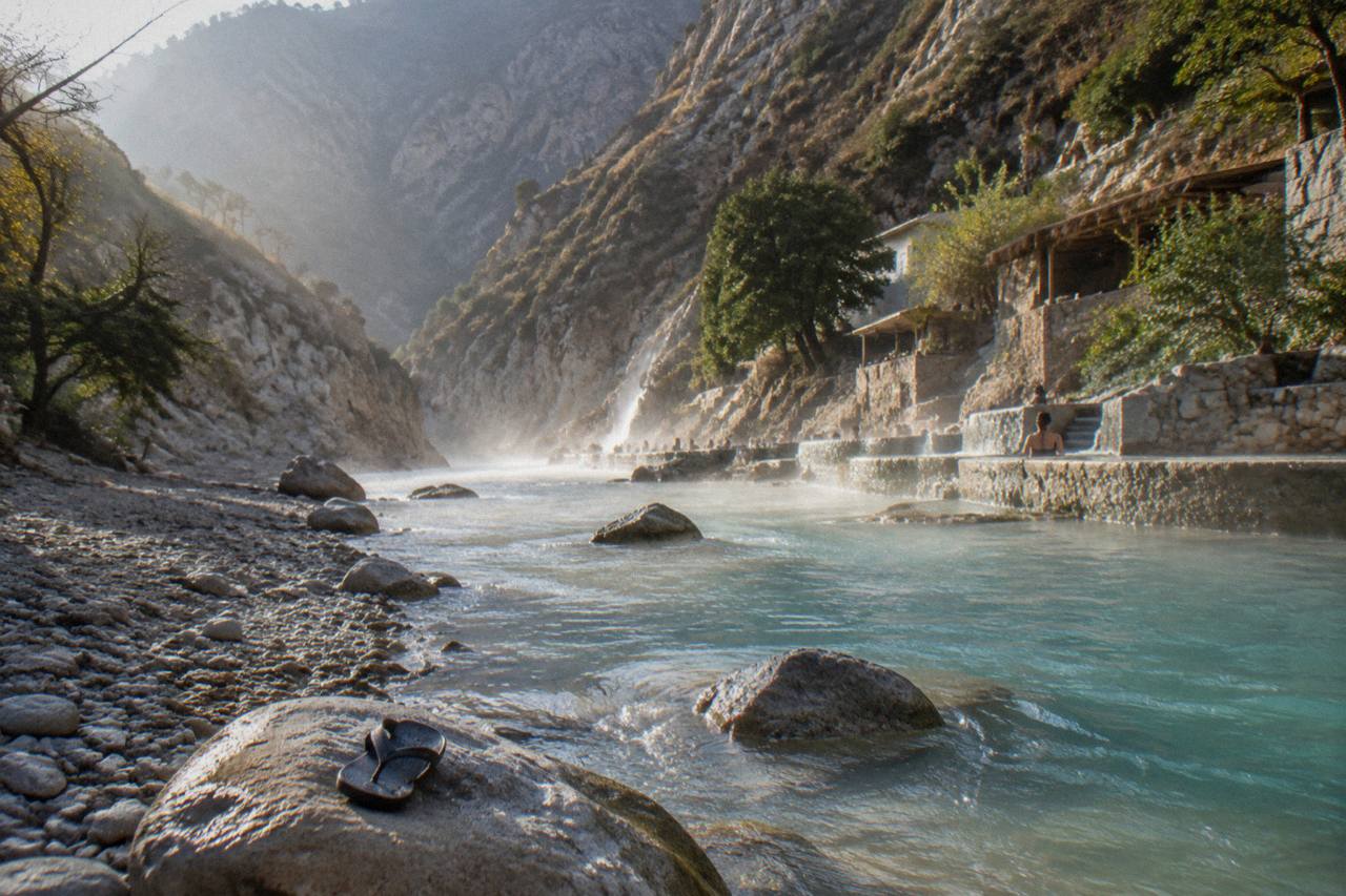 Turquoise thermal river flowing between steep canyon walls at Tolantongo