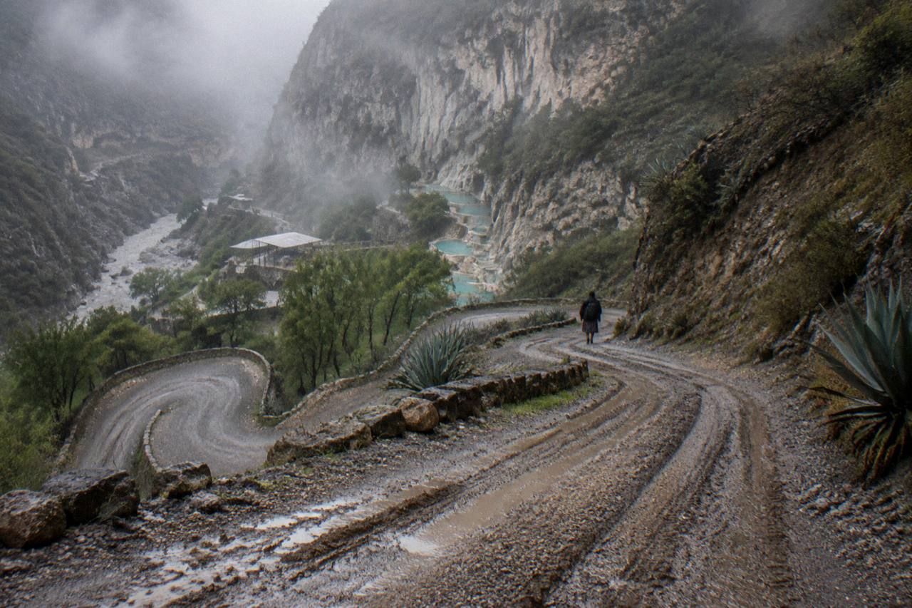 A curving mountain road descending toward the canyon entrance