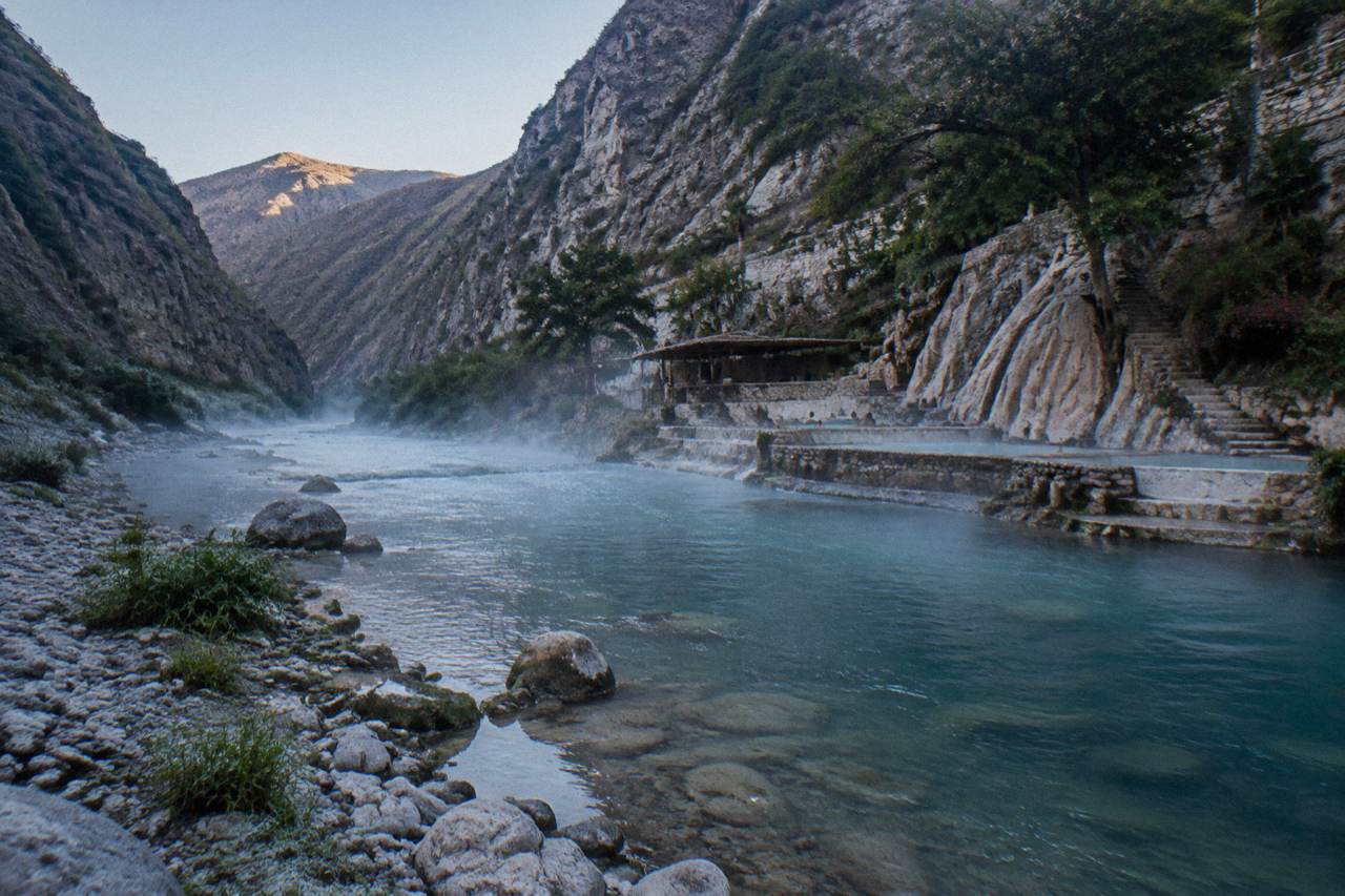 People-free view along a thermal river bed between canyon walls at dawn