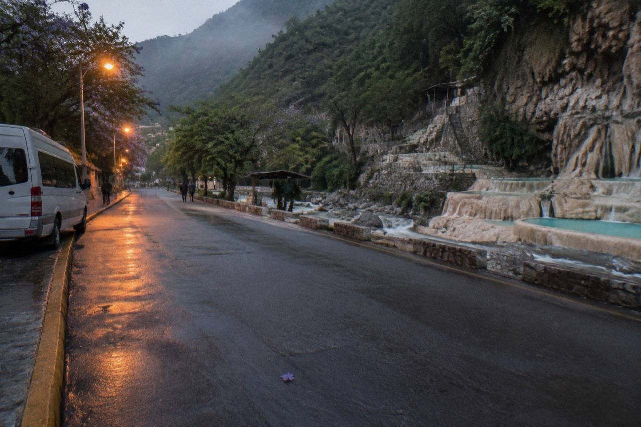 Empty city avenue at dawn with streetlights still glowing