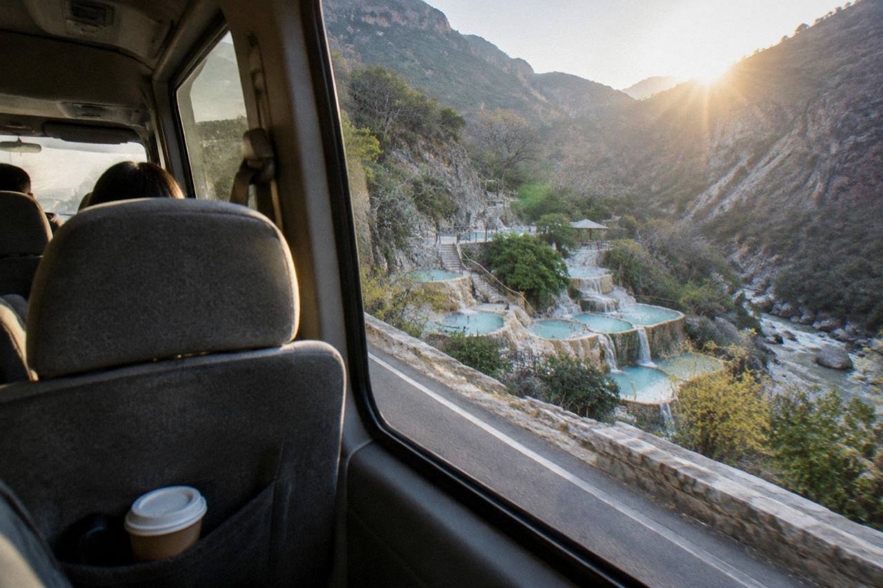 Tourist van interior seen from a back seat on a mountain highway at sunrise
