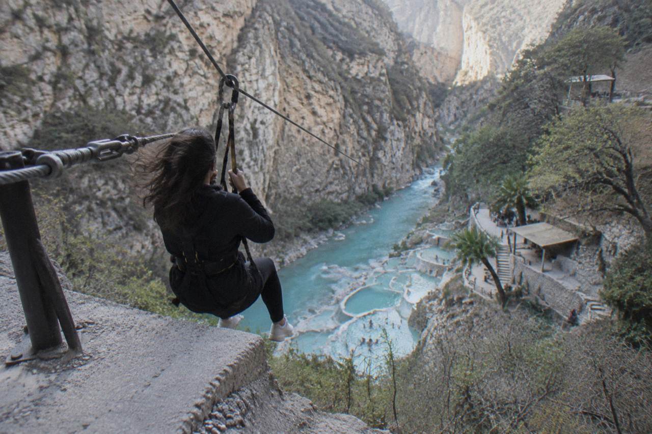 Zipline cable crossing high above the turquoise thermal river at Tolantongo