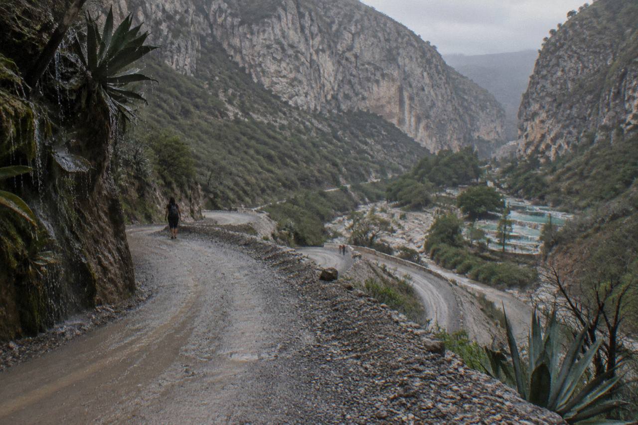 Winding mountain road descending toward the Tolantongo canyon with canyon walls visible ahead