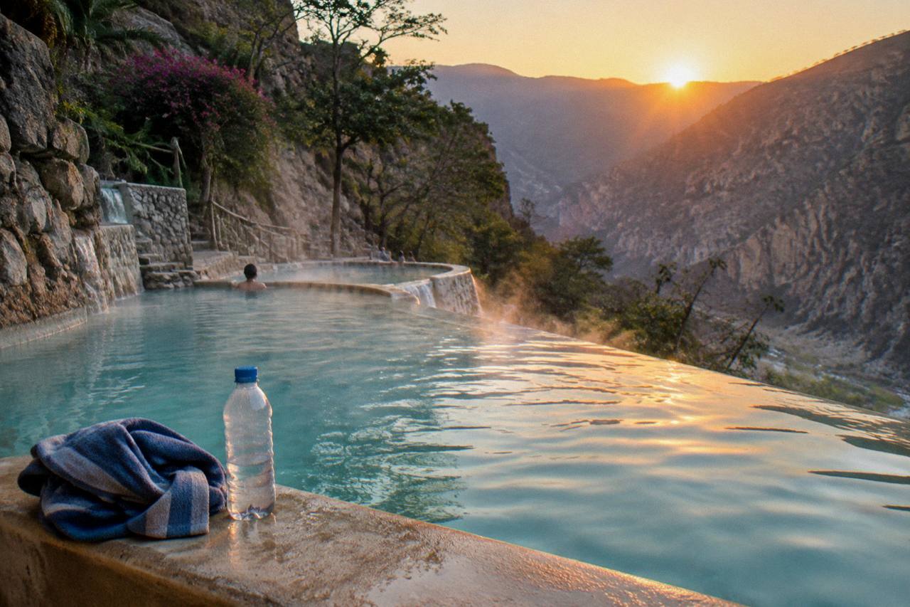 Steam rising from warm thermal pools in the early morning light above the canyon
