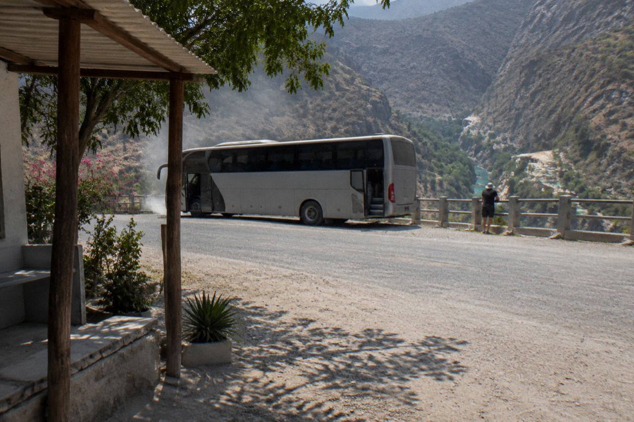 A tour bus parked at the canyon rim viewpoint above the thermal park