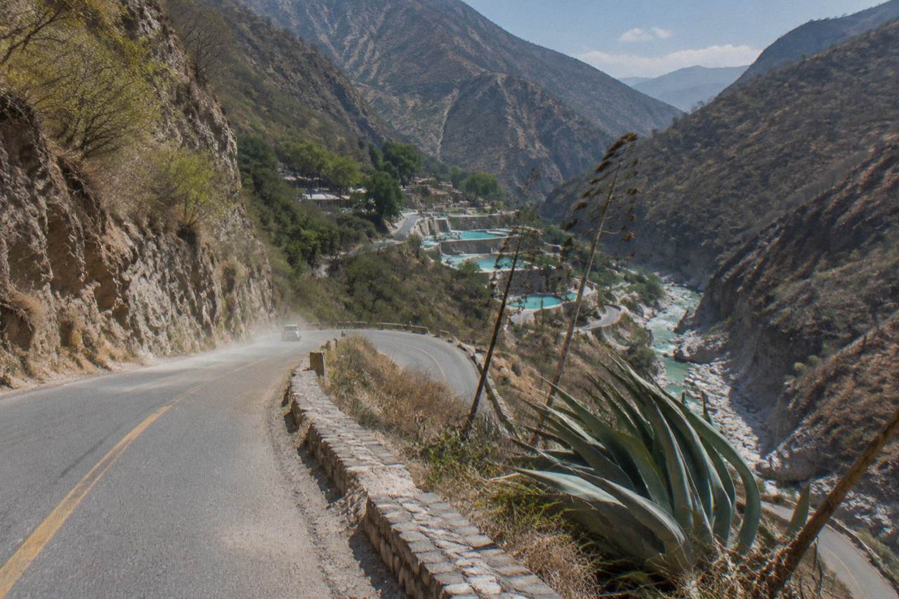 A paved mountain road with tight curves descending into a deep canyon