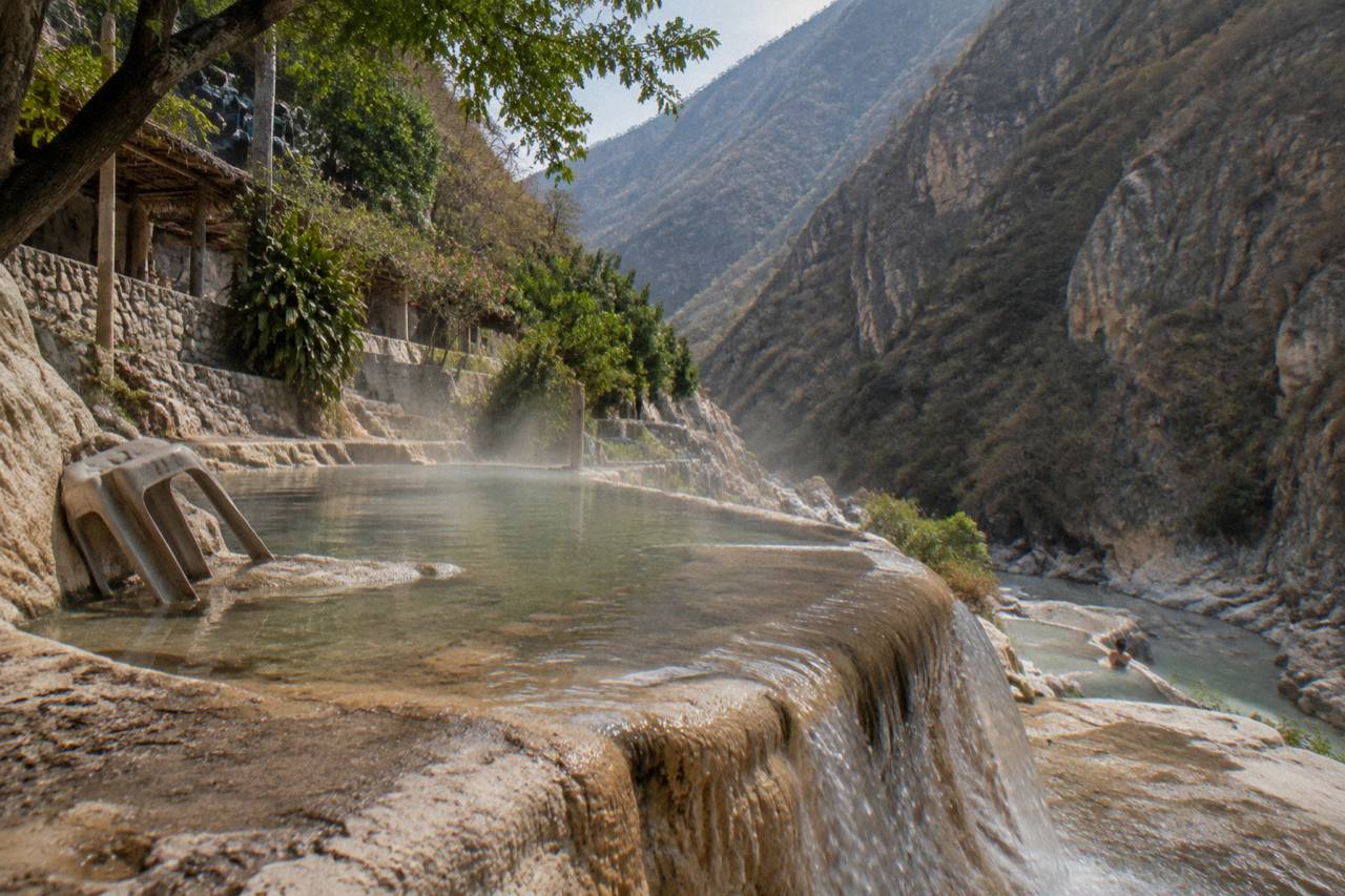 Warm water pooling on rock terraces with canyon walls rising above