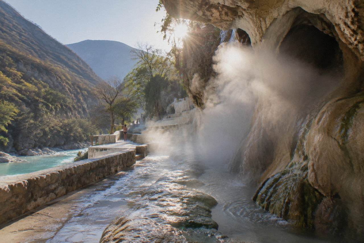 Steam rising from the cave entrance where thermal water flows out of the rock