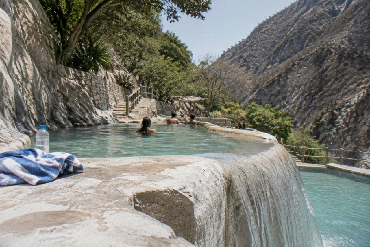 Warm thermal water spilling over a stone edge into a natural pool