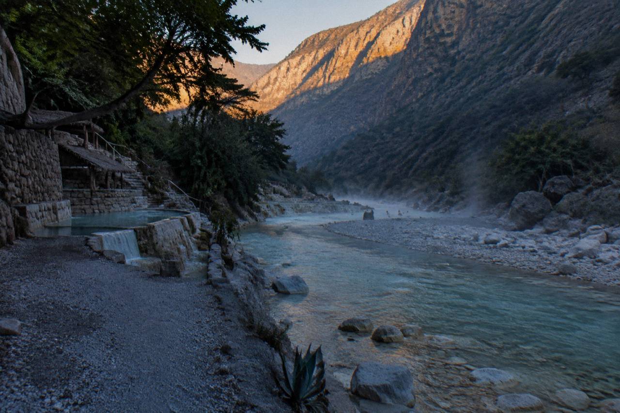 Shallow warm thermal river winding through a canyon with rocky banks