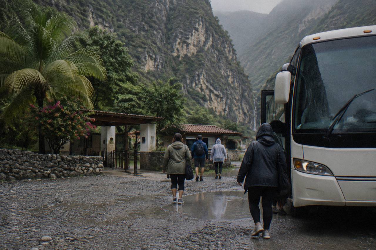 Tour bus parked at the entrance of Grutas de Tolantongo with passengers getting off