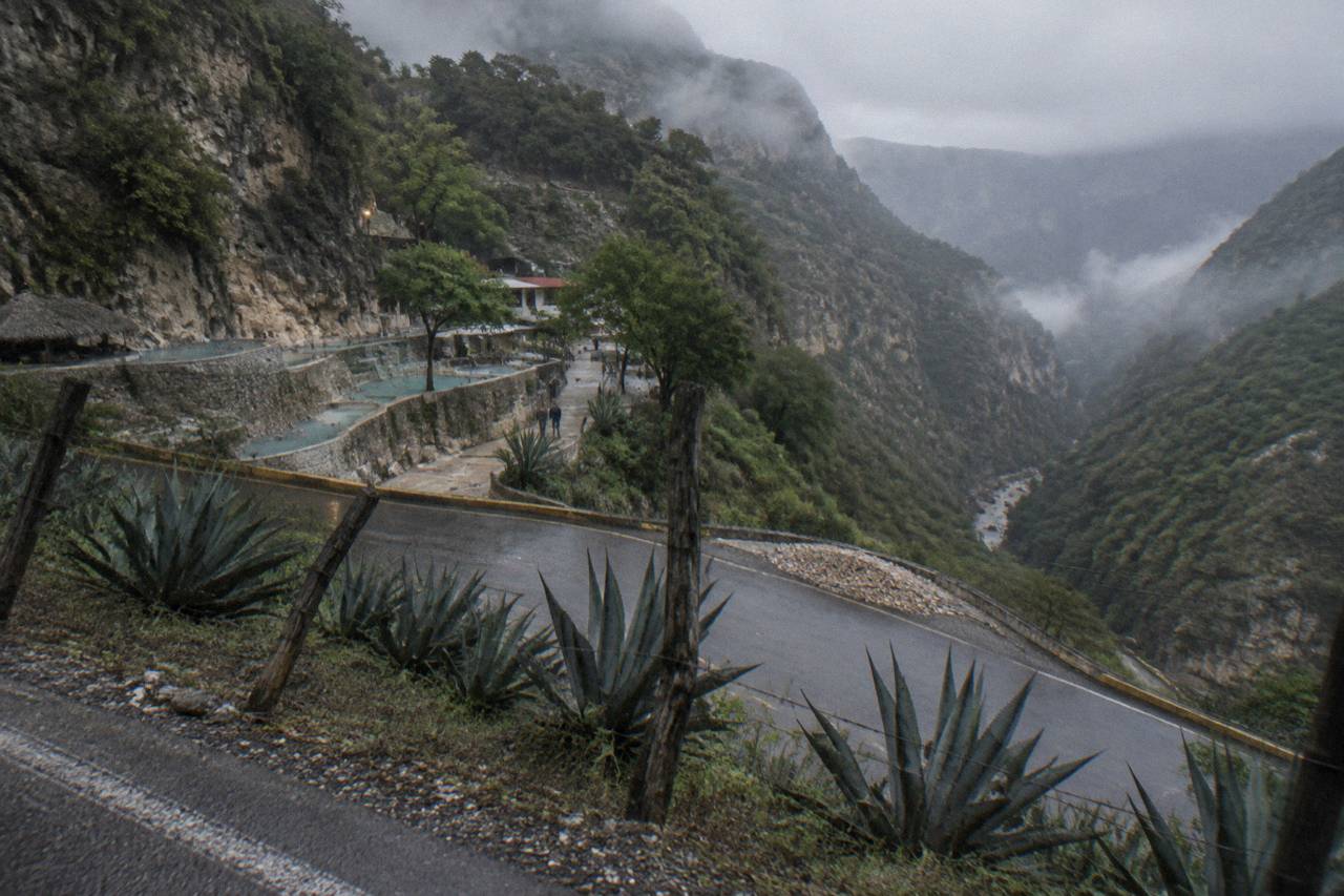 A winding paved mountain road descending toward a deep green canyon