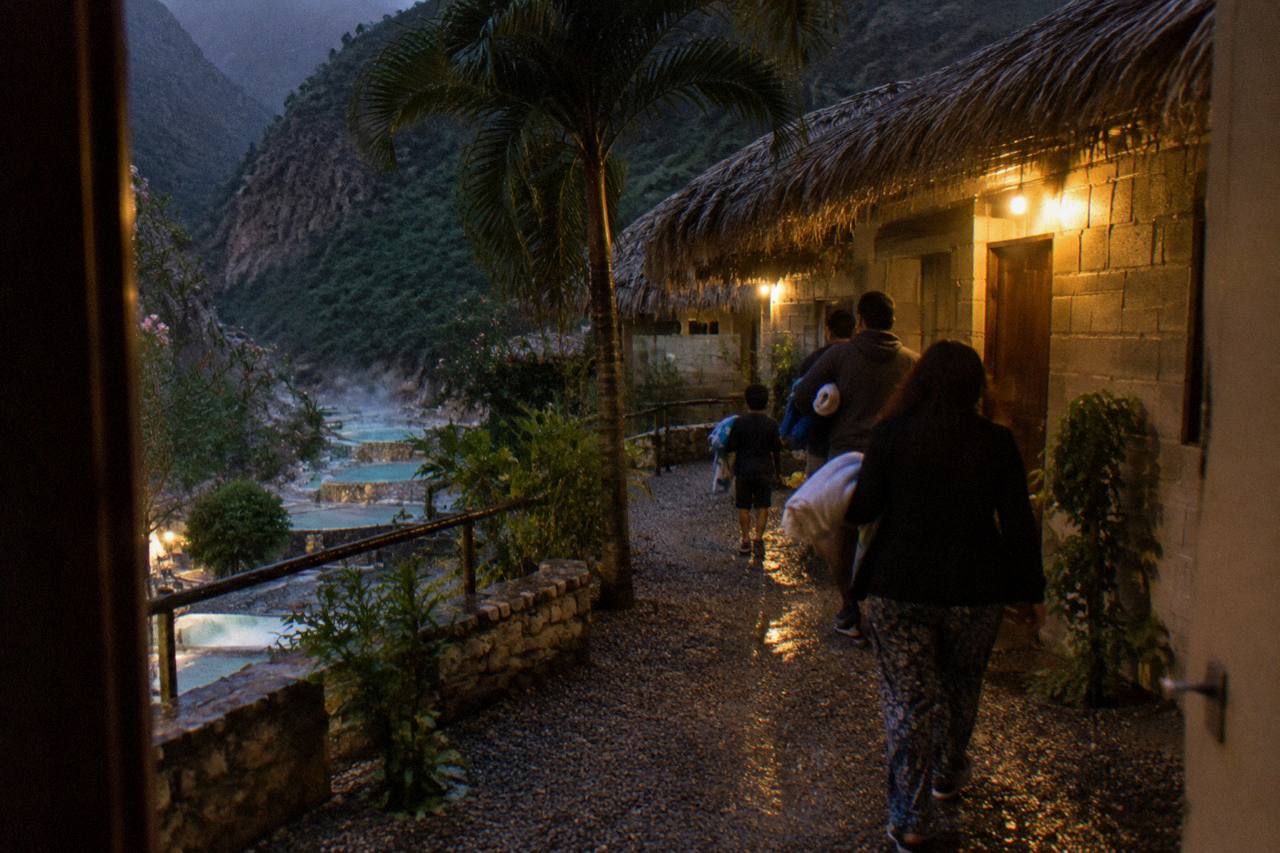 Simple rooms and palm-thatched roofs on a canyon terrace near warm water
