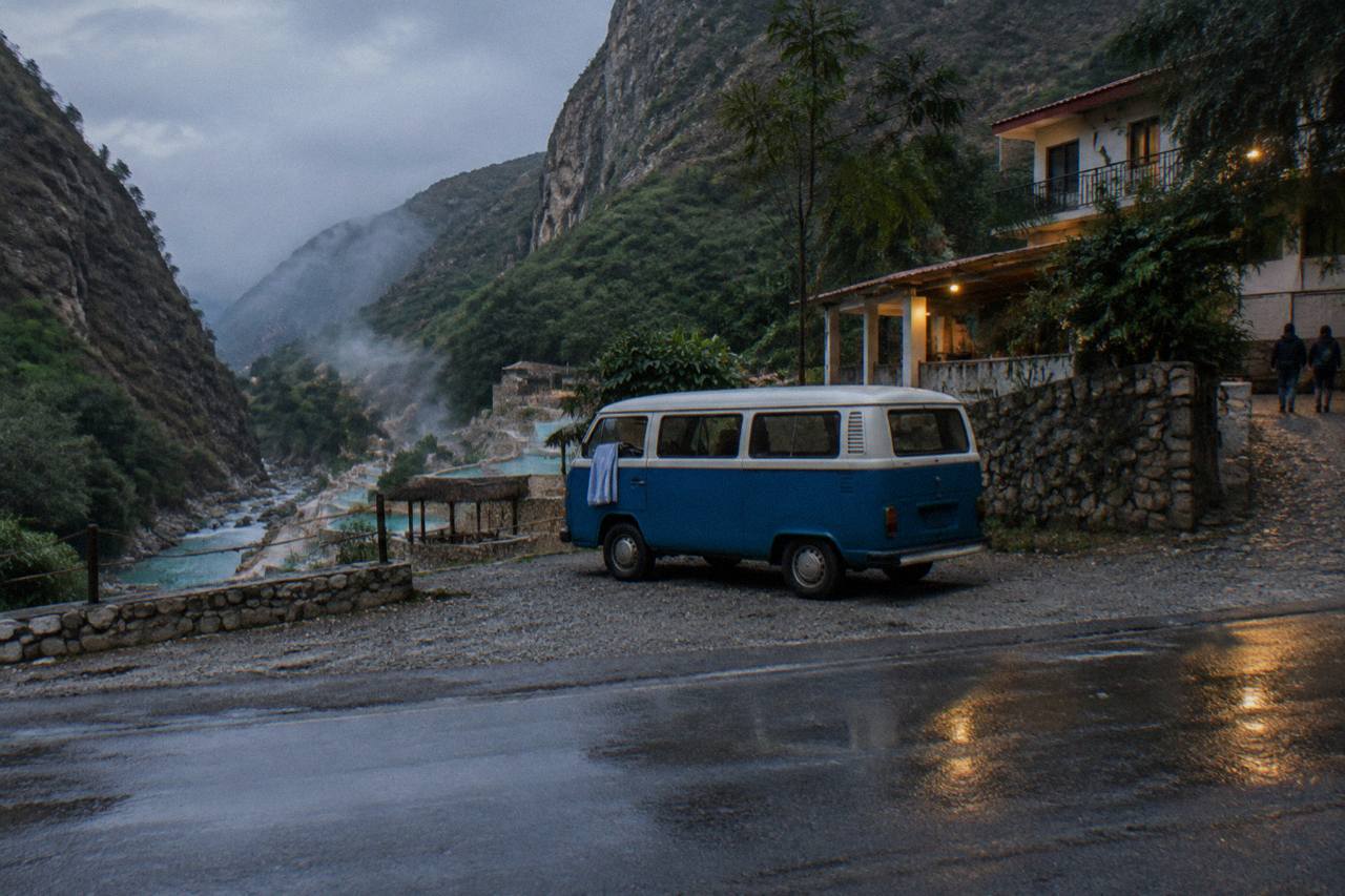 Blue and white combi van parked on a mountain road above the Tolantongo canyon