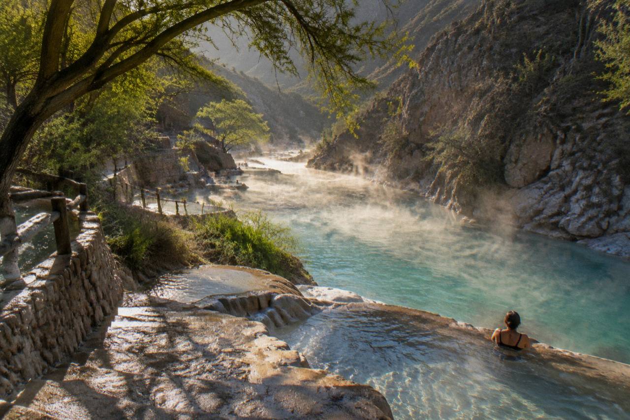 Steam rising from the thermal river in early morning light inside the canyon